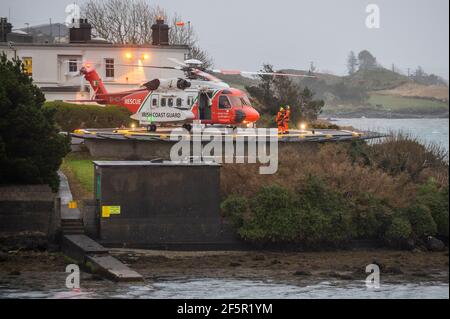 Castletownbere, West Cork, Irlanda. 27 Marzo 2021. L'elicottero della guardia costiera irlandese Rescue 115 atterra per ricaricarsi a Castletownbere prima di andare all'assistenza del peschereccio a strascico "Ellie Adhamh". Il motore del peschereccio da traino è fallito ieri e da allora sta andando in moto. Irish Naval Vessel The 'le George Bernard Shaw' The Castletownbere RNLI Lifeboat stanno assistendo il peschereccio sulla scena. Credit: AG News/Alamy Live News Foto Stock