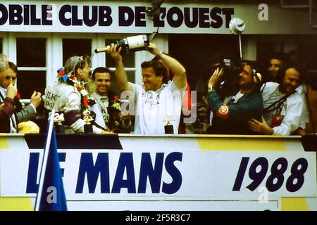 12.06.1988. Le Mans 24 ore. Tom Walkinshaw versa champagne sul driver Jonny Dumfries. Dumfries, vero nome John Colum Crichton-Stuart, settimo marchese di Bute, è scomparso il 22 marzo 2021 dopo una breve malattia Foto Stock