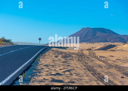 Strada che attraversa le dune di sabbia di Corralejo a Fuerteventura, isole Canarie, Spagna. Foto Stock