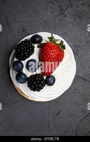 Il dessert Pavlov con panna bianca e frutta Foto Stock