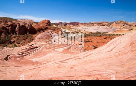 L'onda nella valle del Fire state Park in Nevada durante l'estate con rocce nere, ocra, rosse sotto il cielo blu Foto Stock