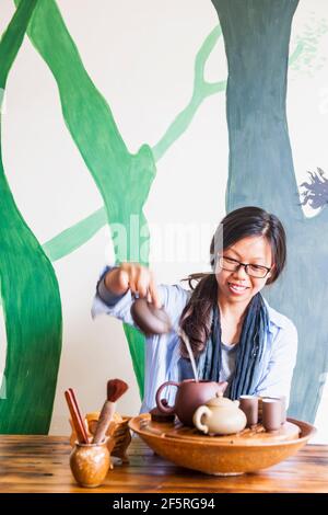 Donna cinese che versa il tè verde durante la tradizionale cerimonia del tè Foto Stock