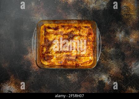 Lasagne di carne classica con formaggio Set di bechamel e salsa bolognese, in teglia, su fondo rustico scuro antico, vista dall'alto, piatto, con spazio per la copia Foto Stock