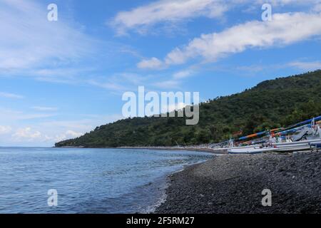 Jemeluk spiaggia e jukung barche in giornata di sole a Bali, Indonesia. Amed è diventata una popolare destinazione turistica ed è situato sulla costa orientale di Bali Foto Stock