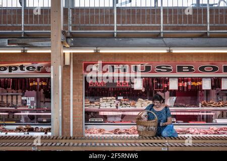 SZEGED, UNGHERIA - 21 LUGLIO 2017: Donna che impacchettano cibo di fronte ad un macellaio (Husbol) nel mercato agricolo coperto di Szeged, chiamato anche Szegedi Mars ter Foto Stock