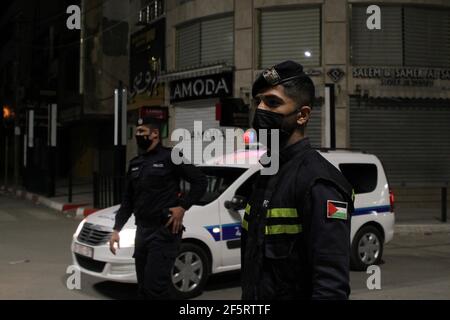 Gaza. 27 Marzo 2021. Ufficiali di polizia palestinesi stanno in guardia in strada a Gaza, 27 marzo 2021. Il Ministero degli interni gestito da Hamas ha imposto un blocco completo il sabato in tutta la striscia di Gaza di notte dalle 21:00 a causa del numero crescente di infezioni COVID-19. Credit: Rizek Abdeljawad/Xinhua/Alamy Live News Foto Stock