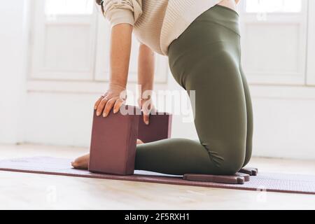 Bella donna di mezza età in abbigliamento sportivo pactice yoga con attrezzature in studio luminoso Foto Stock