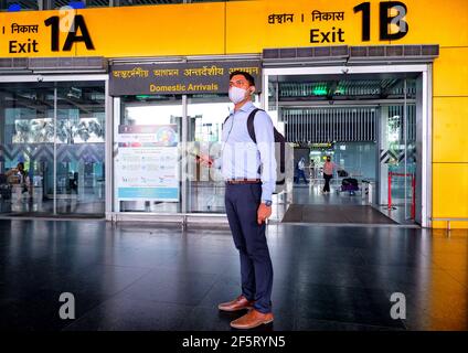 Kolkata, India. 27 Marzo 2021. Un uomo che indossa una maschera ti aspetta di fronte all'uscita del terminal dell'aeroporto di Kolkata. Il governo indiano ha limitato tutti i movimenti delle compagnie aeree internazionali fino al 31 marzo 2021 per limitare la seconda ondata di pandemia di Covid 19. Credit: SOPA Images Limited/Alamy Live News Foto Stock