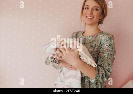 la ragazza tiene una pila di biancheria da letto colorata in le mani Foto Stock