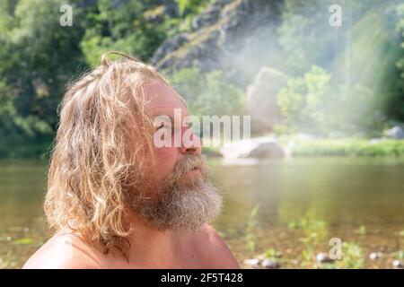 Concetto di conoscenza di sé, comunicazione con Dio, ricerca di te stesso. Uomo maturo con vista pensiva sulla riva Foto Stock