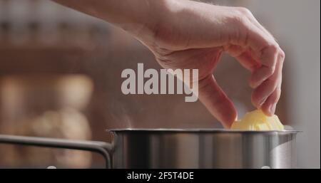 mano dell'uomo mettere la pasta di fettuccine in pentola con chiocciole d'acqua bollente, foto ampia Foto Stock