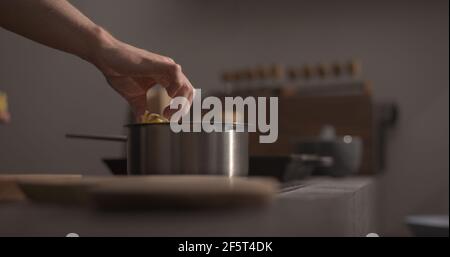 mano dell'uomo mettere la pasta di fettuccine in pentola con chiocciole d'acqua bollente, foto ampia Foto Stock