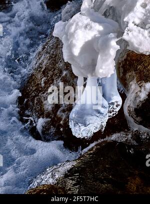 Concetto di bellezza e grandezza della natura: Una spettacolare forma di ghiaccio sospeso sul fiume in inverno in montagna Foto Stock