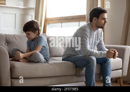 Papà arrabbiato e figlio piccolo evitare di parlare dopo la lotta Foto Stock