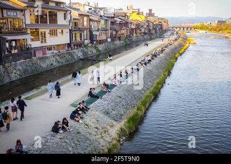 People relaxing along the Kamogawa (Kamo River) in Kyoto, Japan. Foto Stock