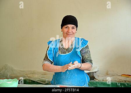 Preparazione del qutab, un piatto azerbaigiano a base di pasta sottilmente arrotolata ripiena di verdure che viene cucinata brevemente su una griglia Foto Stock