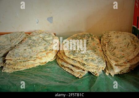 Preparazione del qutab, un piatto azerbaigiano a base di pasta sottilmente arrotolata ripiena di verdure che viene cucinata brevemente su una griglia Foto Stock