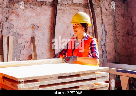 Donna operaio alla pianta, indossando giallo duro Foto Stock