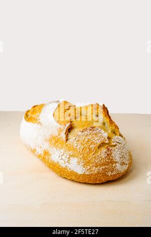 Pane delizioso con farina sulla superficie dorata in panetteria sfondo bianco Foto Stock