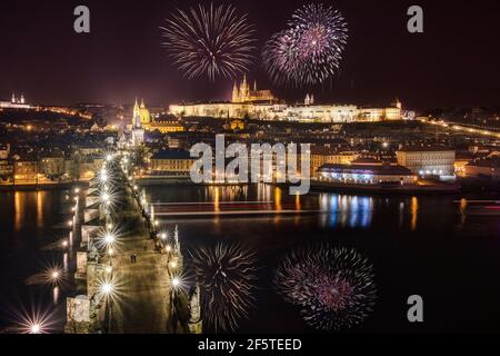 Splendida vista su fuochi d'artificio luminosi che esplodono nel cielo notturno scuro sopra la città con edifici illuminati Foto Stock