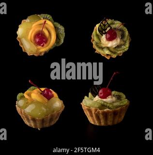 Torta da dessert alla frutta con ciliegie, shekolad, spugne d'uva, fette di kiwi e fette d'arancia, su fondo nero isolato, collage Foto Stock