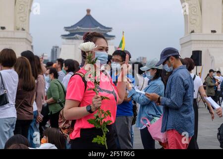 Un manifestante fa un saluto a tre dita mentre tiene un fiore durante la manifestazione. Birmani che vivono a Taiwan insieme con le comunità locali riuniti nella piazza della libertà per chiedere la fine del colpo di stato militare in Myanmar. La polizia e i soldati militari del Myanmar (tatmadow) hanno attaccato i manifestanti con proiettili in gomma, munizioni vive, gas lacrimogeni e bombe stordite in risposta ai manifestanti anti anti anti militari di colpo di stato il sabato in Myanmar uccidendo più di 100 persone e ferendo molte altre. Almeno 300 persone sono state uccise in Myanmar dal colpo di Stato del 1° febbraio, ha affermato un funzionario delle Nazioni Unite per i diritti umani. Myanmar Foto Stock