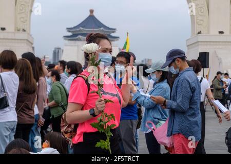 Un manifestante fa un saluto a tre dita mentre tiene un fiore durante la manifestazione. Birmani che vivono a Taiwan insieme con le comunità locali riuniti nella piazza della libertà per chiedere la fine del colpo di stato militare in Myanmar. La polizia e i soldati militari del Myanmar (tatmadow) hanno attaccato i manifestanti con proiettili in gomma, munizioni vive, gas lacrimogeni e bombe stordite in risposta ai manifestanti anti anti anti militari di colpo di stato il sabato in Myanmar uccidendo più di 100 persone e ferendo molte altre. Almeno 300 persone sono state uccise in Myanmar dal colpo di Stato del 1° febbraio, ha affermato un funzionario delle Nazioni Unite per i diritti umani. Myanmar Foto Stock