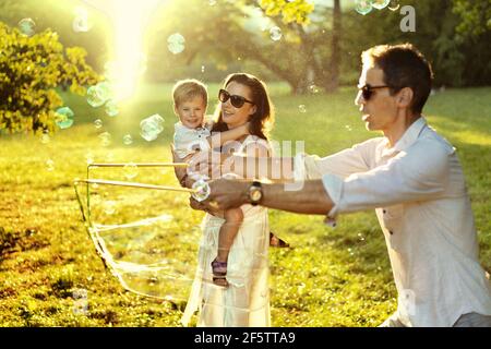 Genitori allegri che godono il tempo estivo con un figlio amato Foto Stock