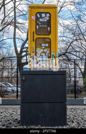 Vecchio telefono giallo scatola su zoccolo nero a Berlino Phone Booth Memorial Park, comunicazione & Ufficio postale Museo, Leipzigerstrasse, Mitte, Berlino Foto Stock