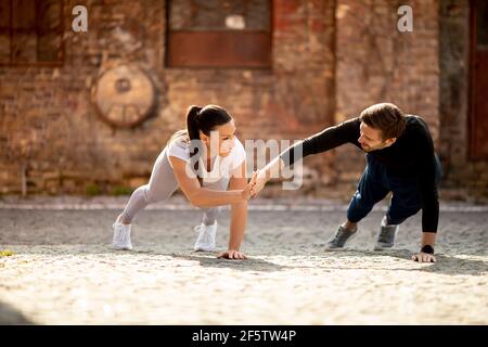 Bella giovane coppia doung un braccio pushup esercizio in ambiente urbano Foto Stock