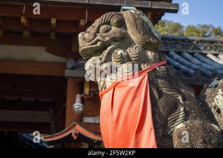 Una statua del cane di leone komainu che protegge l'ingresso al santuario Himuro Jinja shinto a Nara, Giappone Foto Stock