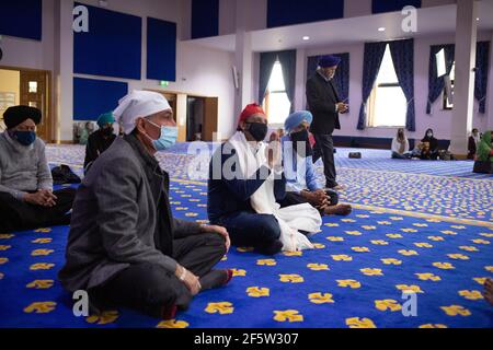 Glasgow, Regno Unito, il 28 marzo 2021. ANAS Sarwar (con copertura rossa), leader del Partito laburista scozzese, visita il Central Gurdwara Glasgow, il primo giorno di servizi per la comunità Sikh da quando le restrizioni di blocco hanno cominciato ad alleggerire. Sarwar stava intraprendendo la visita come parte della campagna elettorale per le elezioni parlamentari scozzesi del 6 maggio. Photo credit: Jeremy Sutton-Hibbert/Alamy Live News Foto Stock