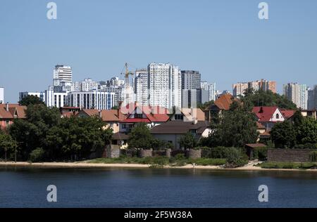 Moderni blocchi torre e vecchi alloggi sulla riva del fiume Dnieper. Periferia di Kiev, Ucraina Foto Stock