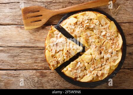 Deliziosa torta di mele invisibile con petali di mandorle da vicino su una tavola di ardesia sul tavolo. Vista orizzontale dall'alto Foto Stock