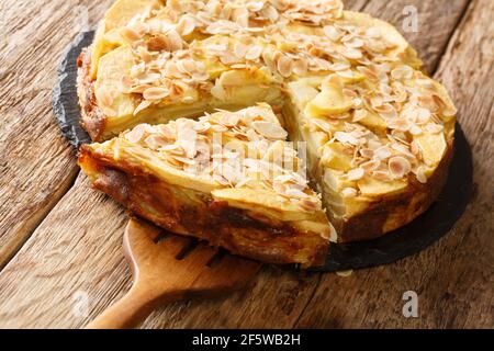 Deliziosa torta di mele invisibile con petali di mandorle primo piano su una tavola di ardesia sul tavolo. Orizzontale Foto Stock