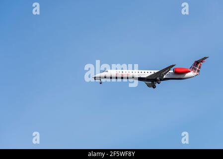 Loganair Embraer ERJ 145 aereo di linea G-SAJL sulle finali per atterrare all'aeroporto Heathrow di Londra, Regno Unito, in cielo blu. Compagnia aerea scozzese. Foto Stock