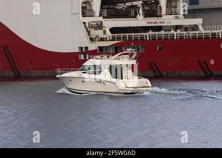 Imbarcazione da diporto Sir Price che passa di fronte a una nave di rifornimento offshore nel porto di Bergen, Norvegia. Foto Stock