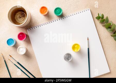 Ambiente di lavoro creativo con album, pennelli, taniche Foto Stock