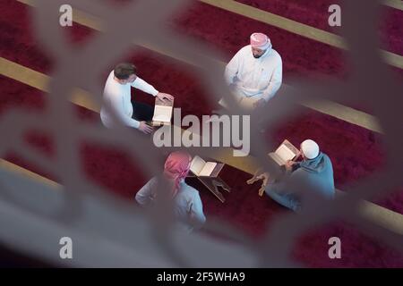 Gruppo di musulmani che leggono, recitano e ricordano Quran durante il ramadanInside moderna e nuova moschea Foto Stock