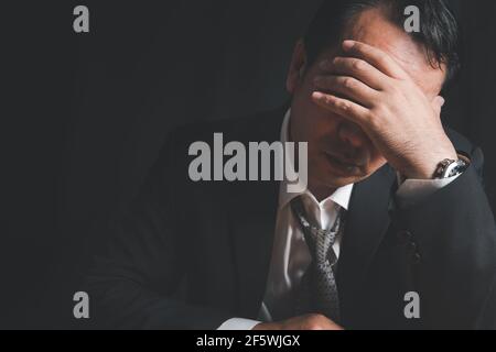 Ha sottolineato l'uomo d'affari che ha problema la crisi finanziaria e il fallimento di affari sopra sfondo nero Foto Stock