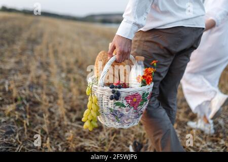 Un cestino con frutta, latte e pane nelle mani di un uomo Foto Stock