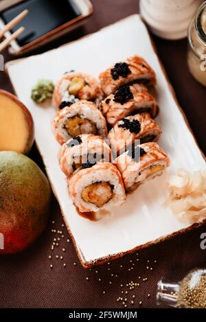 Sushi ben servito con mango e anguilla condito con salsa Foto Stock
