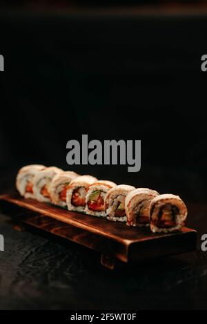 Set di sushi con anguilla e avocado su sfondo nero Foto Stock