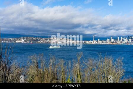 Un traghetto attraversa Elliott Bay di fronte alla Queen Anne Hill di Seattle, Washington. Foto Stock