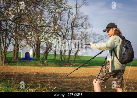Fotografo che ha impostato il treppiede prima di scattare foto della cappella di Santa Barbara in Moravia Toscana. Uomo che fotografa in natura Foto Stock