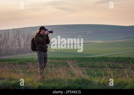 Fotografare la scena rurale durante l'ora d'oro. Uomo con macchina fotografica all'aperto. Fotografo in Moravia Toscana, campagna della Repubblica Ceca Foto Stock