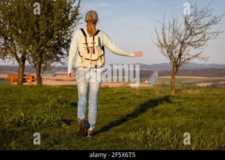 Irresponsabile turista gettando via bottiglia d'acqua in natura. Questioni ambientali. Danni ambientali causati da rifiuti di plastica. Foto Stock