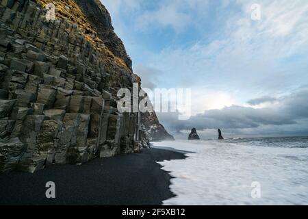 Il basalto formazioni rocciose Troll dita sulla spiaggia nera. a storm Reynisdrangar, Vik, Islanda Foto Stock