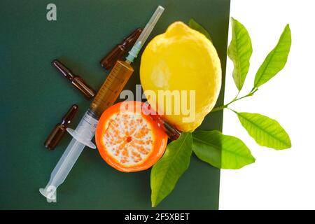 Siero di vitamina C. con fiale di vetro di vitamina C. siringa con soluzione iniettabile e limoni di frutta su fondo verde isolati su fondo bianco Foto Stock