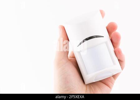 La mano maschio tiene isolato il sensore di movimento su sfondo bianco Foto Stock